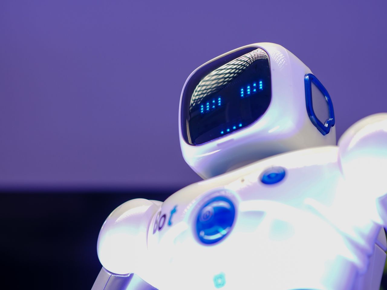 contact-img A modern humanoid robot with digital face and luminescent screen, symbolizing innovation in technology.